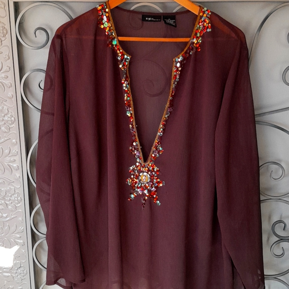 Polyester 100%. With sequin design around neckline and front. NWOT. Lovely top.